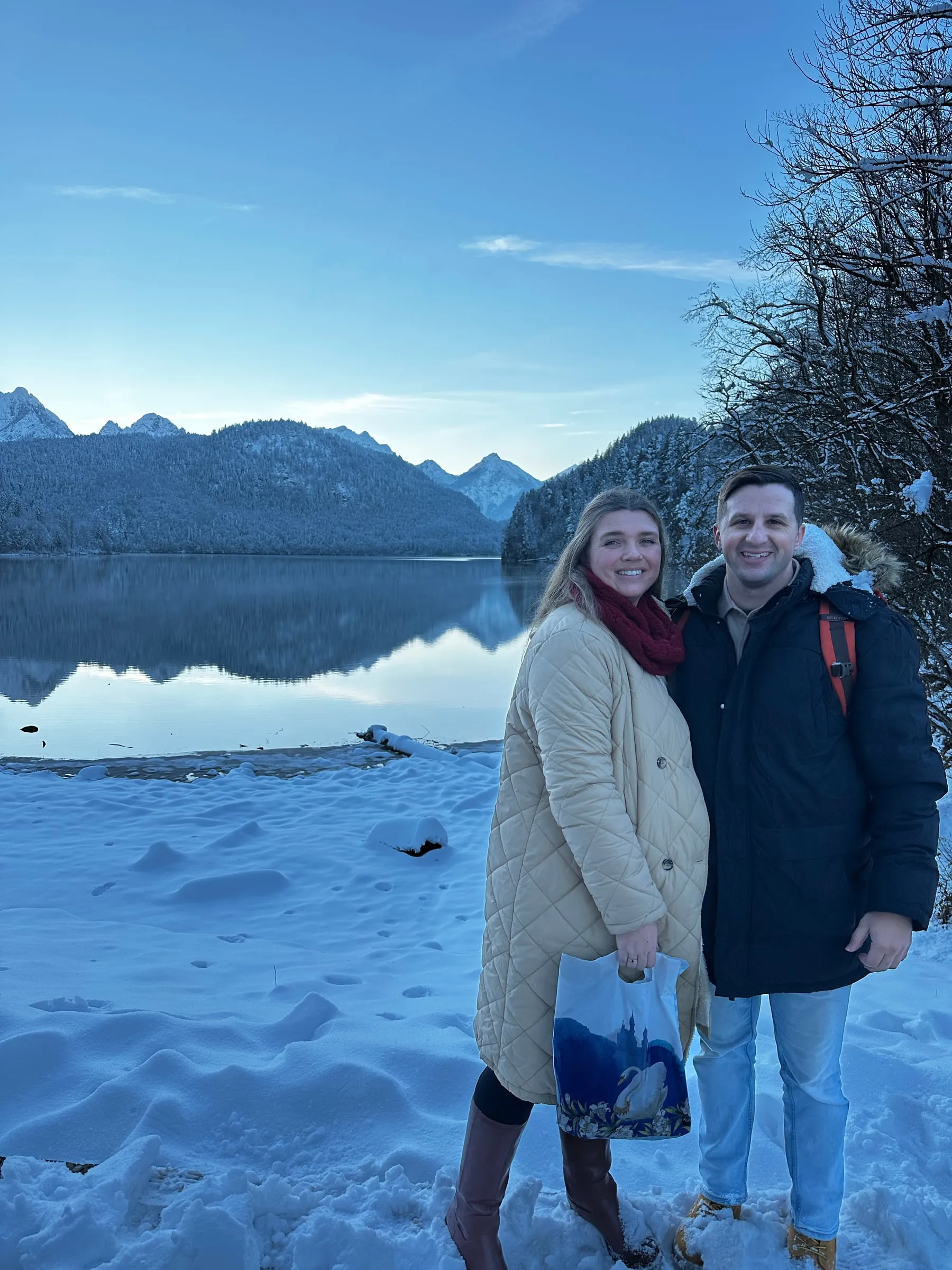 Michael and Chantelle standing in the snow on the shore of the Alpsee