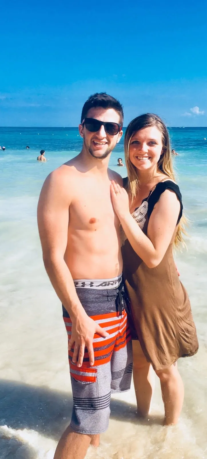 Michael and Chantelle standing knee-deep in the turquoise water in Cancun