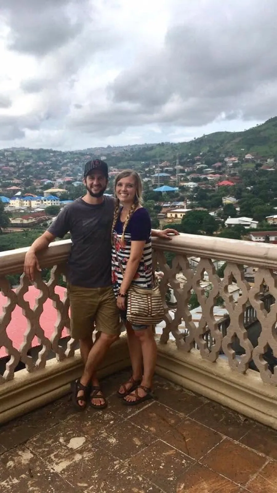 Michael and Chantelle standing at a balcony overlooking the hillside neighborhoods of Freetown