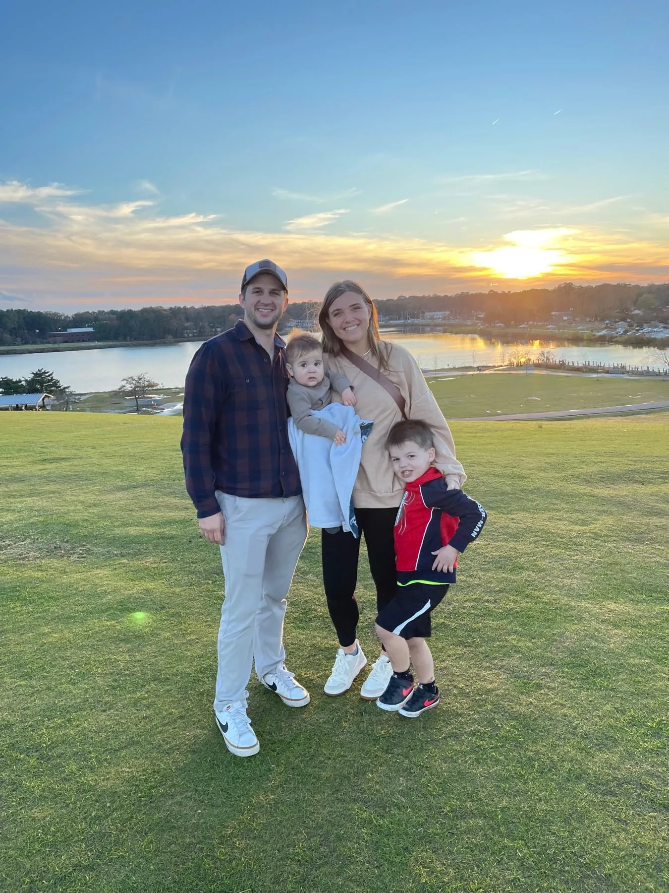 Our family of five standing on the grass by the water at sunset in Virginia