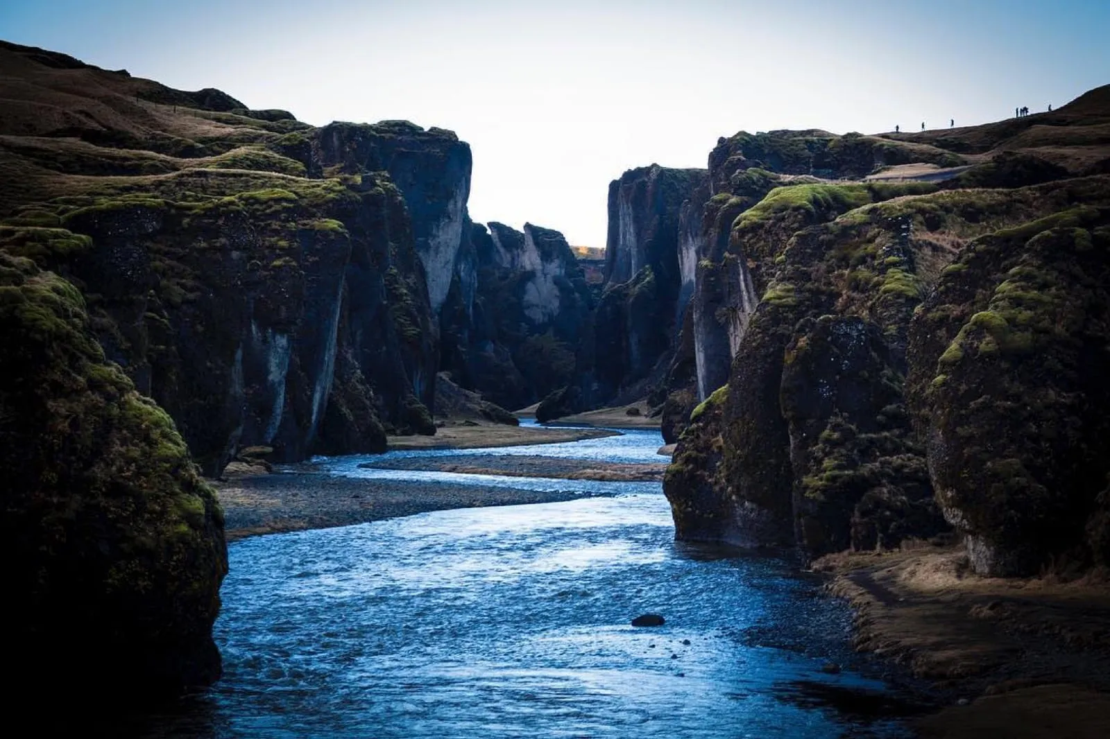 The deep, winding Fjaðrárgljúfur canyon with mossy cliffs and a river at the bottom