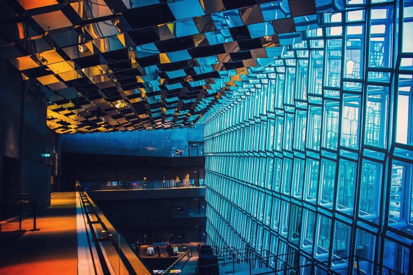The glass honeycomb walls of Harpa concert hall in Reykjavik, glowing blue and gold inside