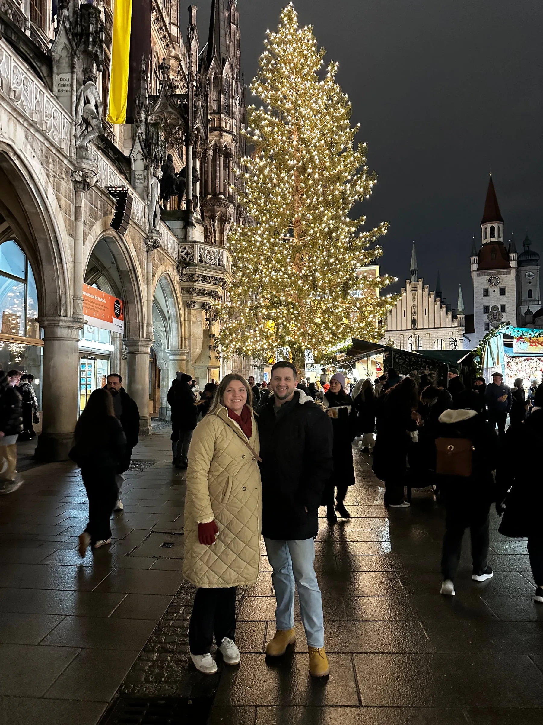 Michael and Chantelle in front of the giant lit Christmas tree at Munich's Marienplatz, with the New Town Hall beside it
