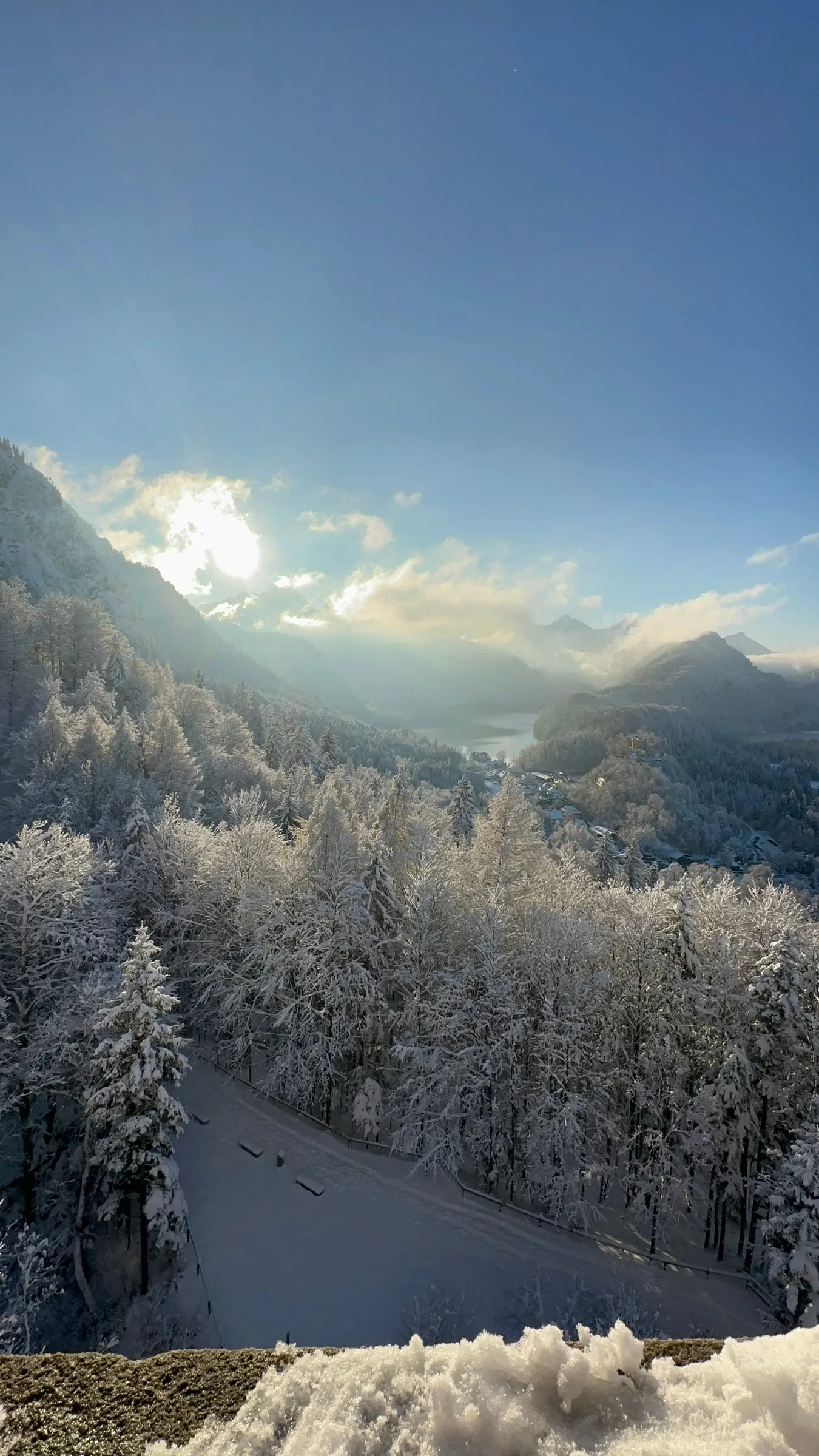 A snowy valley and lake seen from the hillside near Neuschwanstein