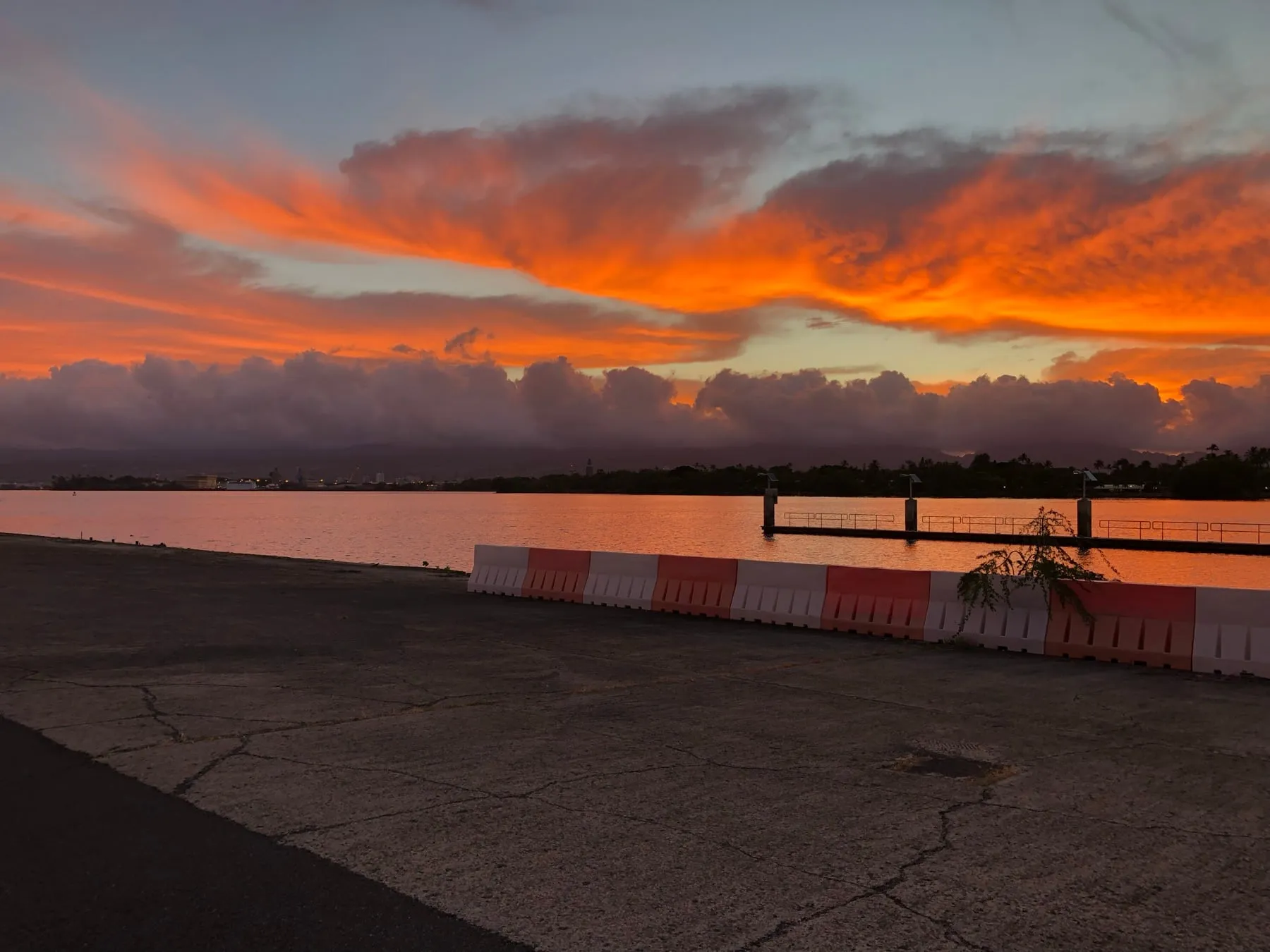 A blazing orange and pink sunset over the water on Oahu