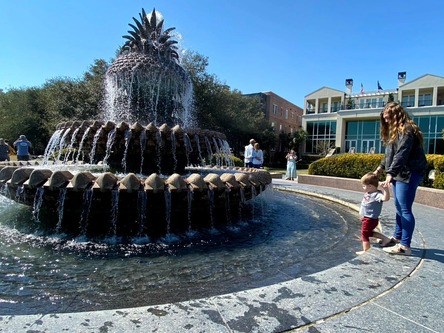 A toddler and his mom by the Pineapple Fountain in Charleston on a sunny day