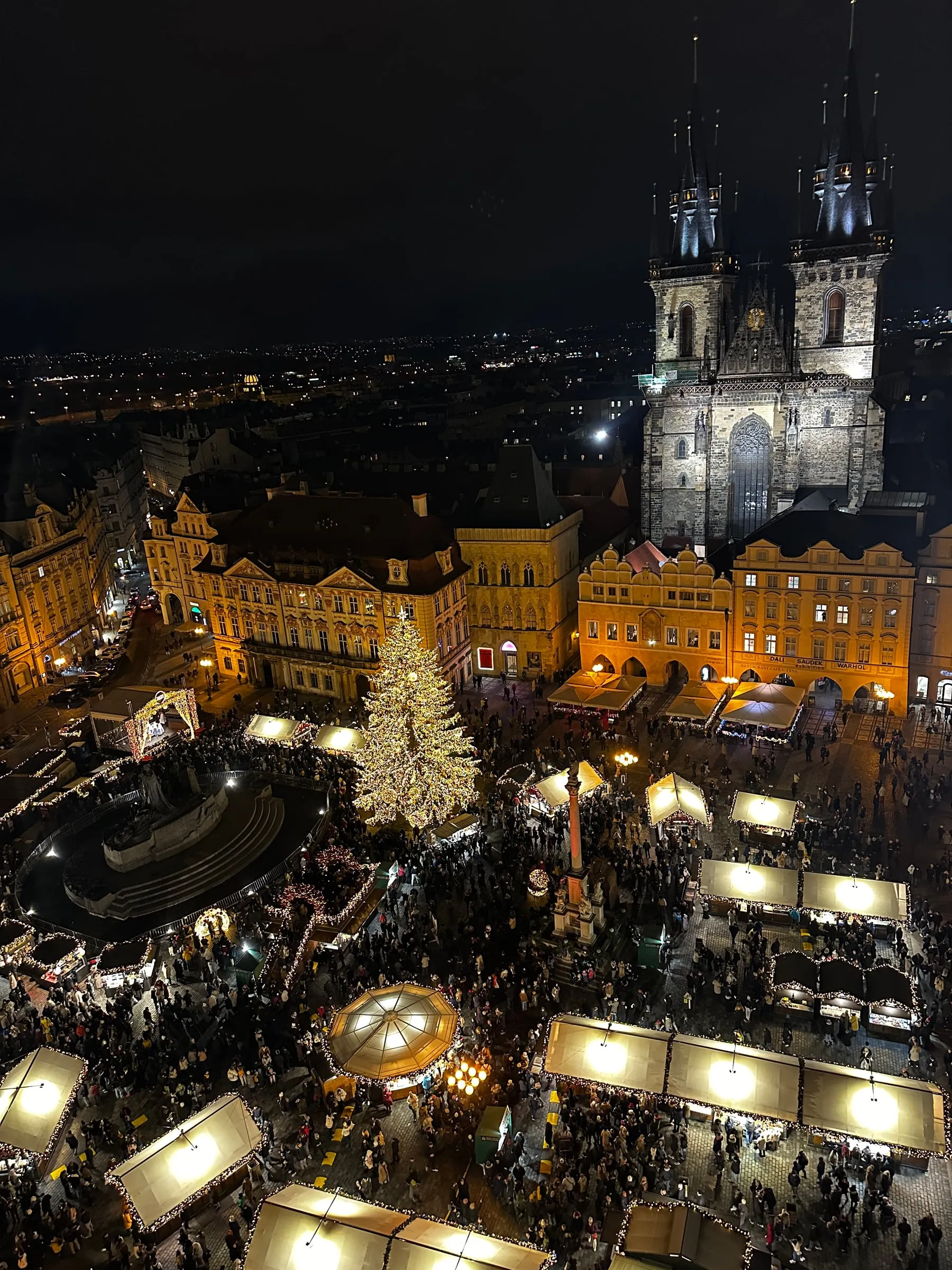 Prague's Old Town Square Christmas market glowing at night, seen from the Old Town Hall tower