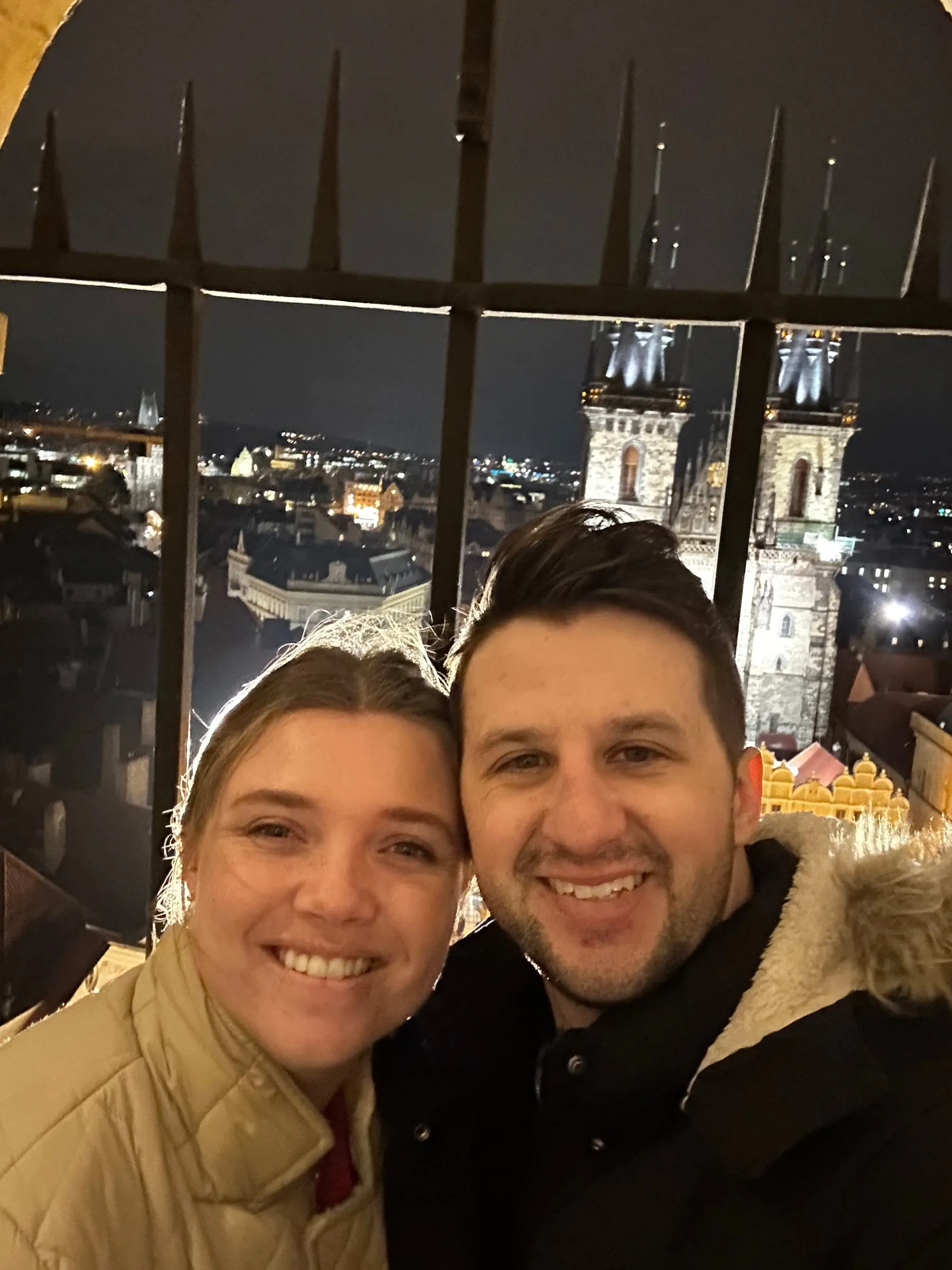 Michael and Chantelle taking a selfie at the top of the Old Town Hall tower with the Týn Church behind them