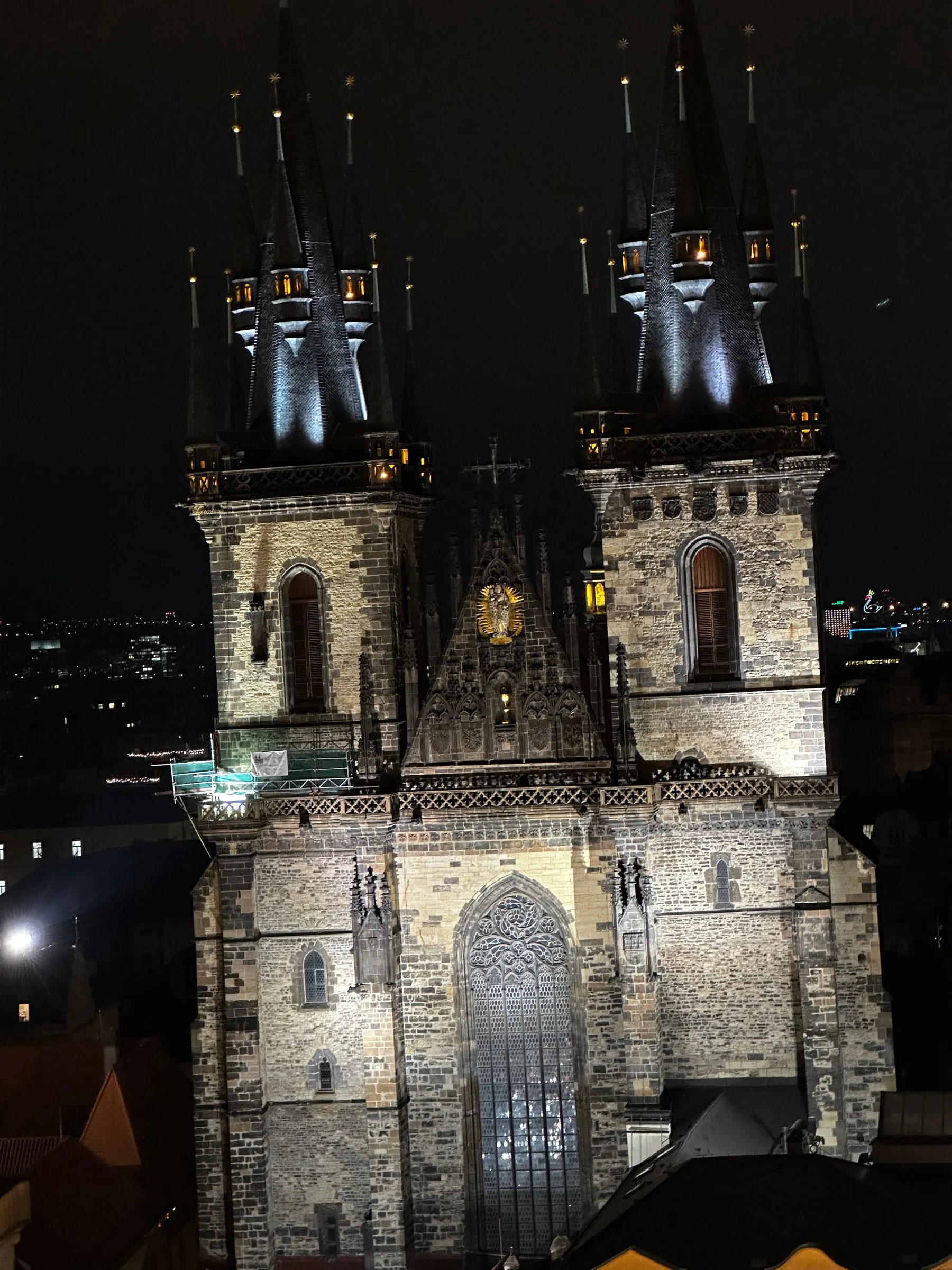 The Týn Church towers lit up at night above Old Town Square