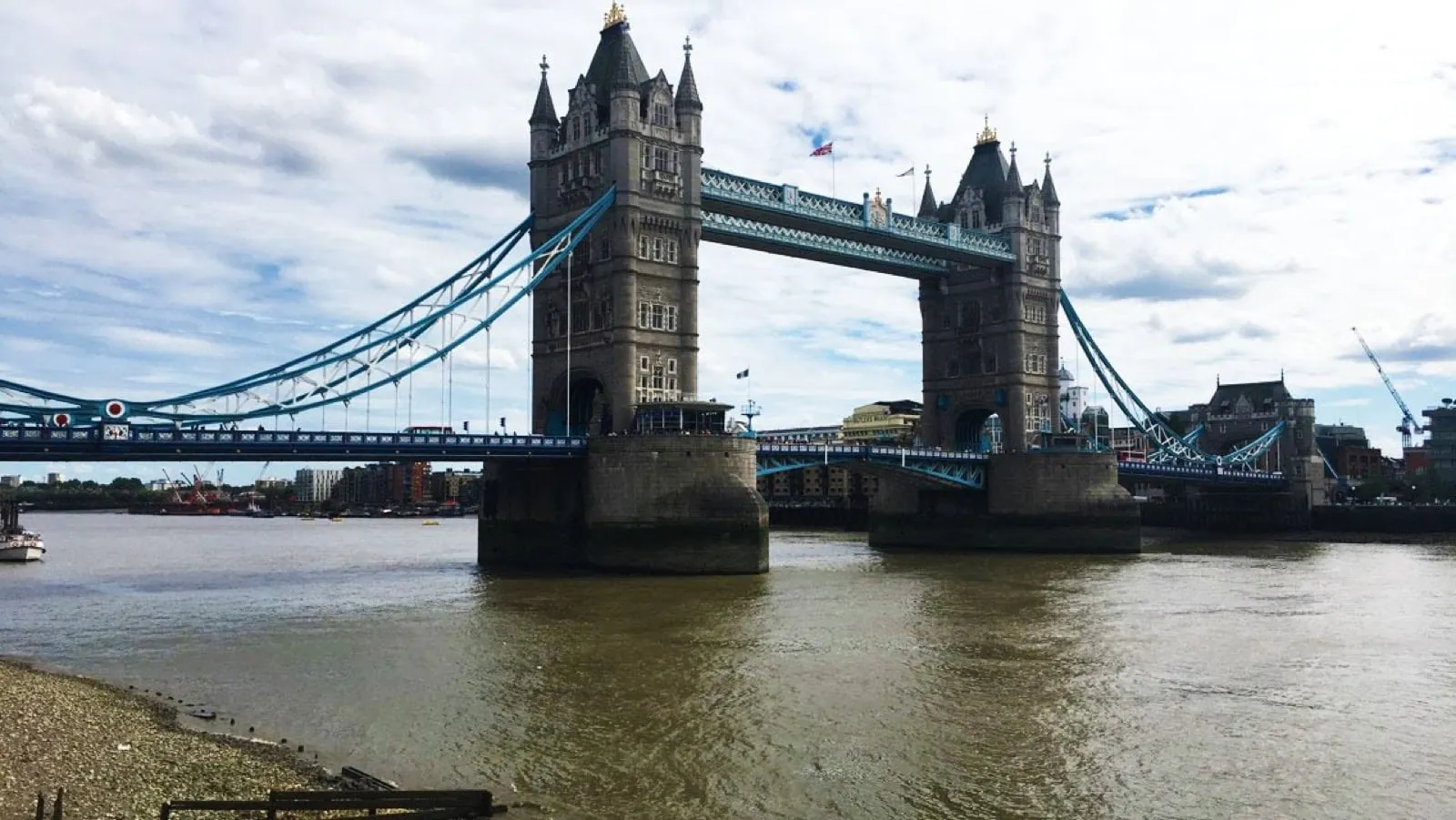 Tower Bridge over the River Thames in London, its two stone towers joined by blue walkways