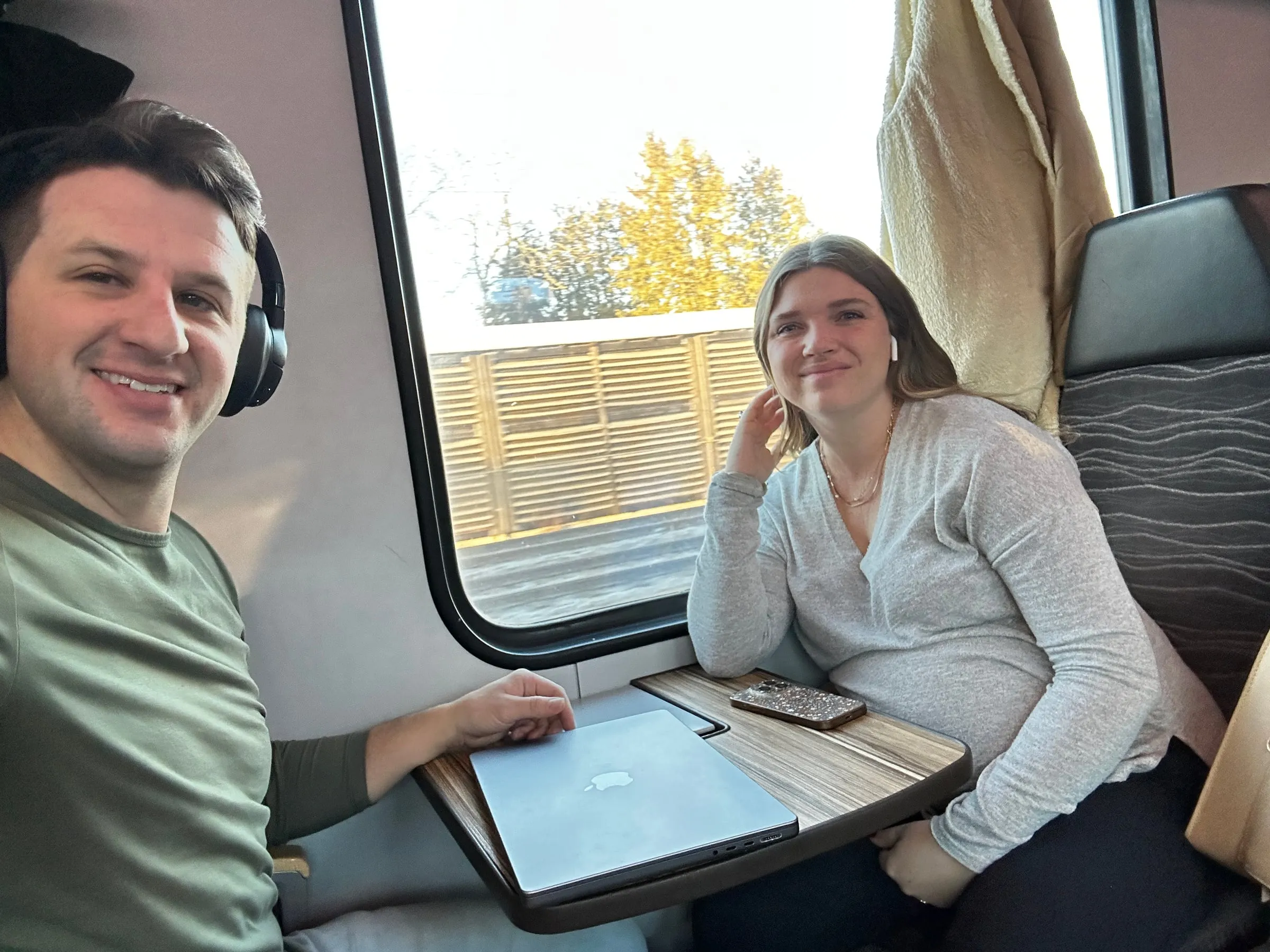 Michael and Chantelle at a small table seat on a train with sun coming through the window